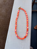Necklace with orange and pink beads on a white surface